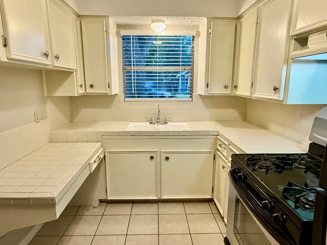 a kitchen with a sink stove and cabinets