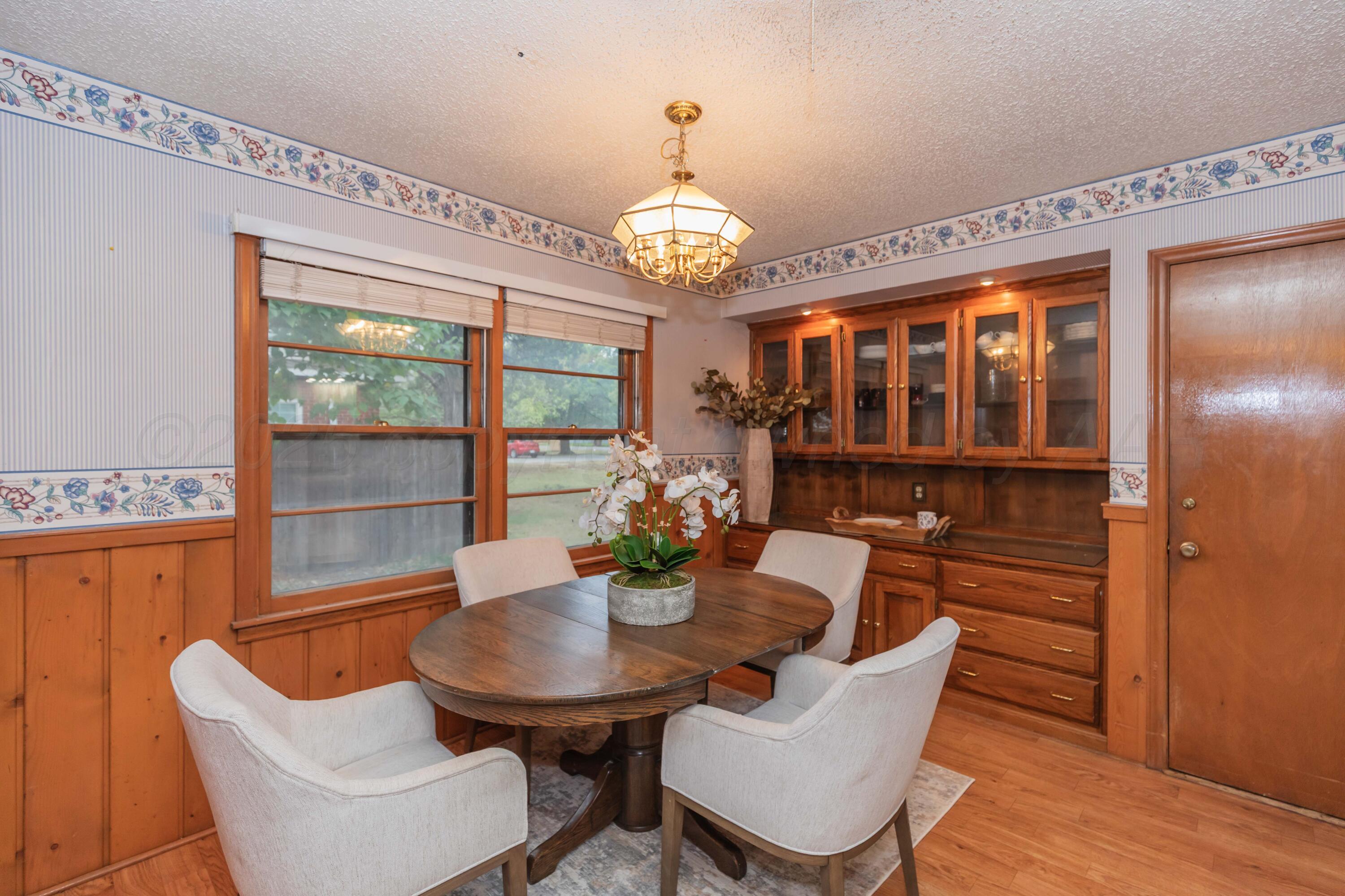 4221 Arden Road Amarillo, TX 79110 - Photo 18 of 50 a view of a dining room with furniture a chandelier and wooden floor
