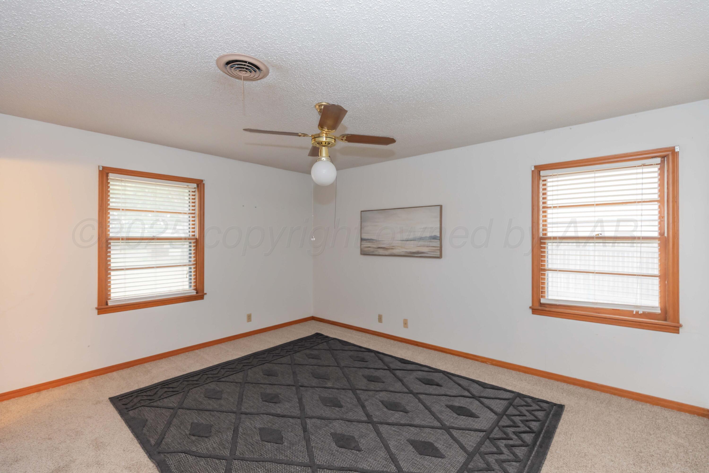 4221 Arden Road Amarillo, TX 79110 - Photo 5 of 50 a view of an empty room with a window and wooden floor