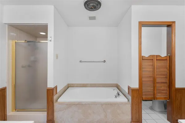 a spacious bathroom with a tub sink and mirror