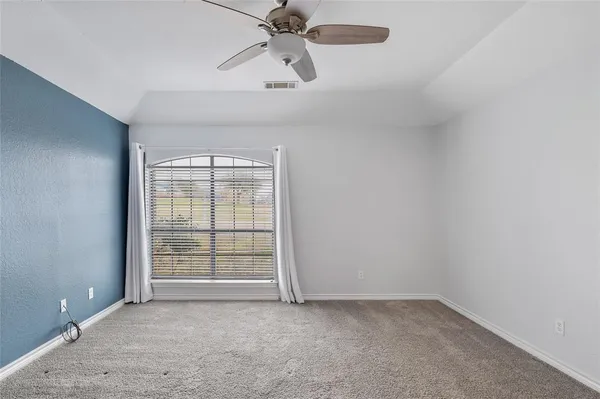 an empty room with closet and a chandelier fan