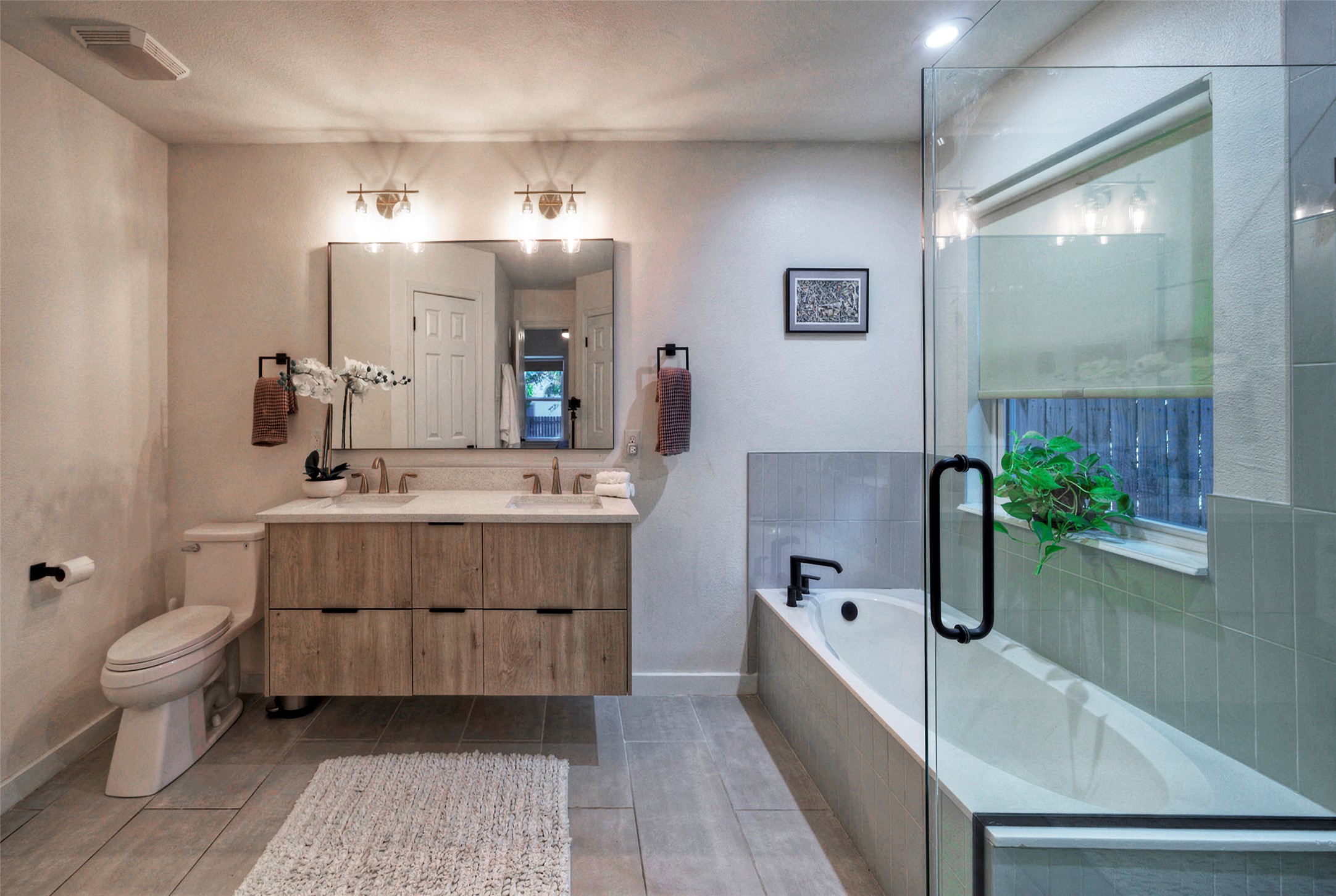 8406 Los Ranchos Drive Austin, TX 78749 - Photo 17 of 32 Modern appointments adorn this well-lit bathroom, featuring a dual-sink vanity and a spacious soaking tub.