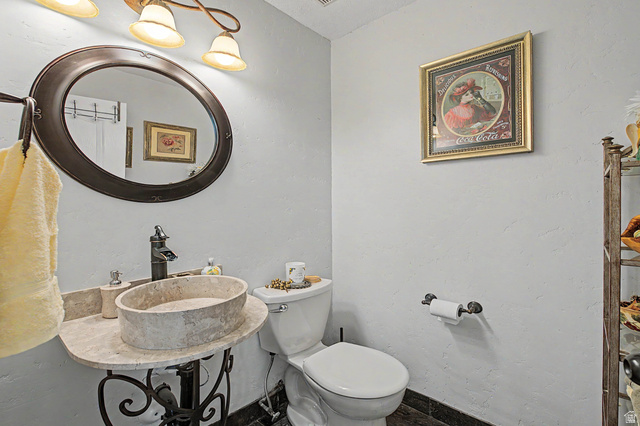 3034 Swiss Drive Santa Clara, UT 84765 - Photo 46 of 59 Bathroom featuring a stone vessel sink, dark bronze-finish faucet, and a round framed mirror