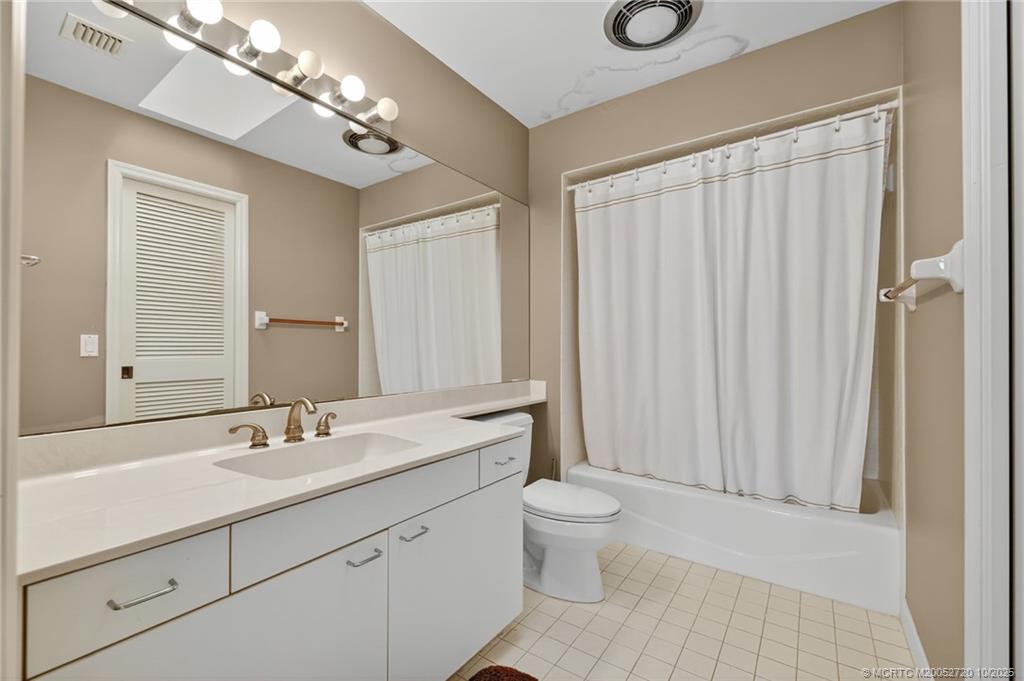6957 Southeast Pacific Drive Stuart, FL 34997 - Photo 23 of 71 a bathroom with a toilet a sink and a mirror