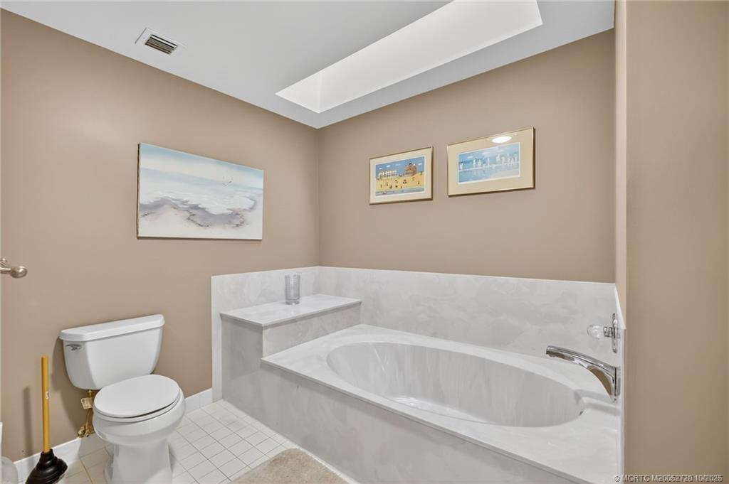 6957 Southeast Pacific Drive Stuart, FL 34997 - Photo 30 of 71 a white bath tub sitting next to a white toilet