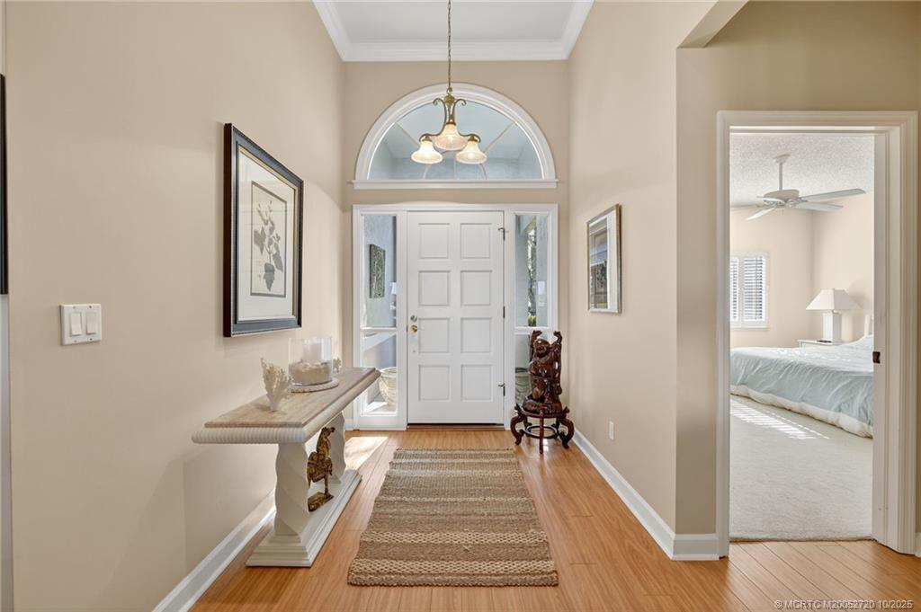 6957 Southeast Pacific Drive Stuart, FL 34997 - Photo 3 of 71 a view of a hallway with wooden floor and a living room