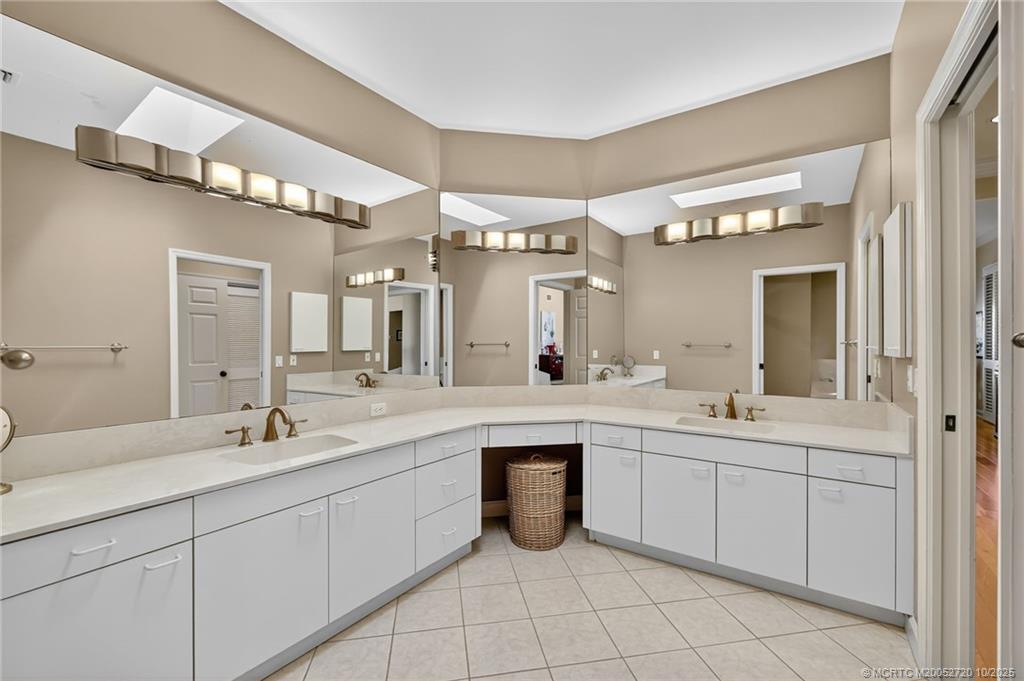 6957 Southeast Pacific Drive Stuart, FL 34997 - Photo 32 of 71 a spacious bathroom with a sink double vanity and a mirror