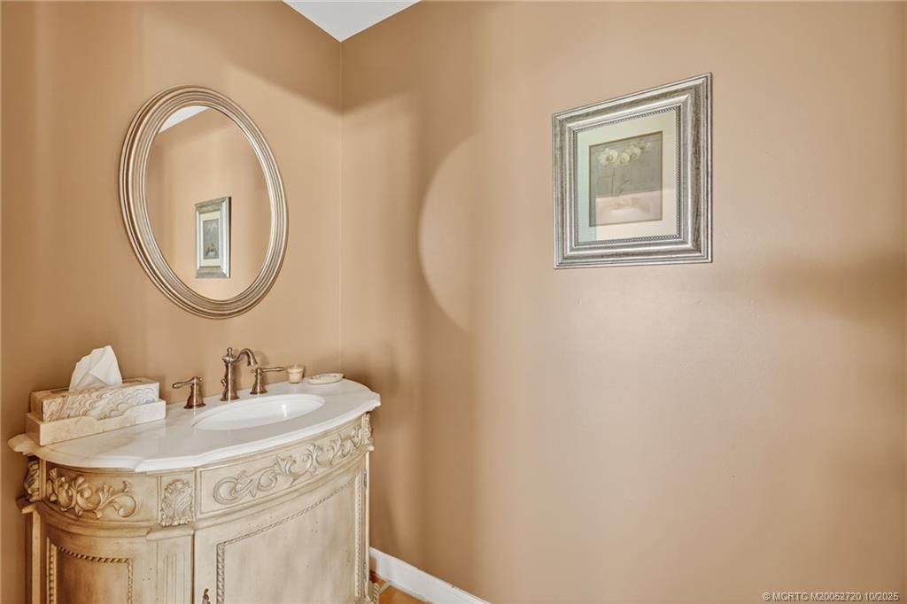 6957 Southeast Pacific Drive Stuart, FL 34997 - Photo 36 of 71 a bathroom with a sink and a mirror