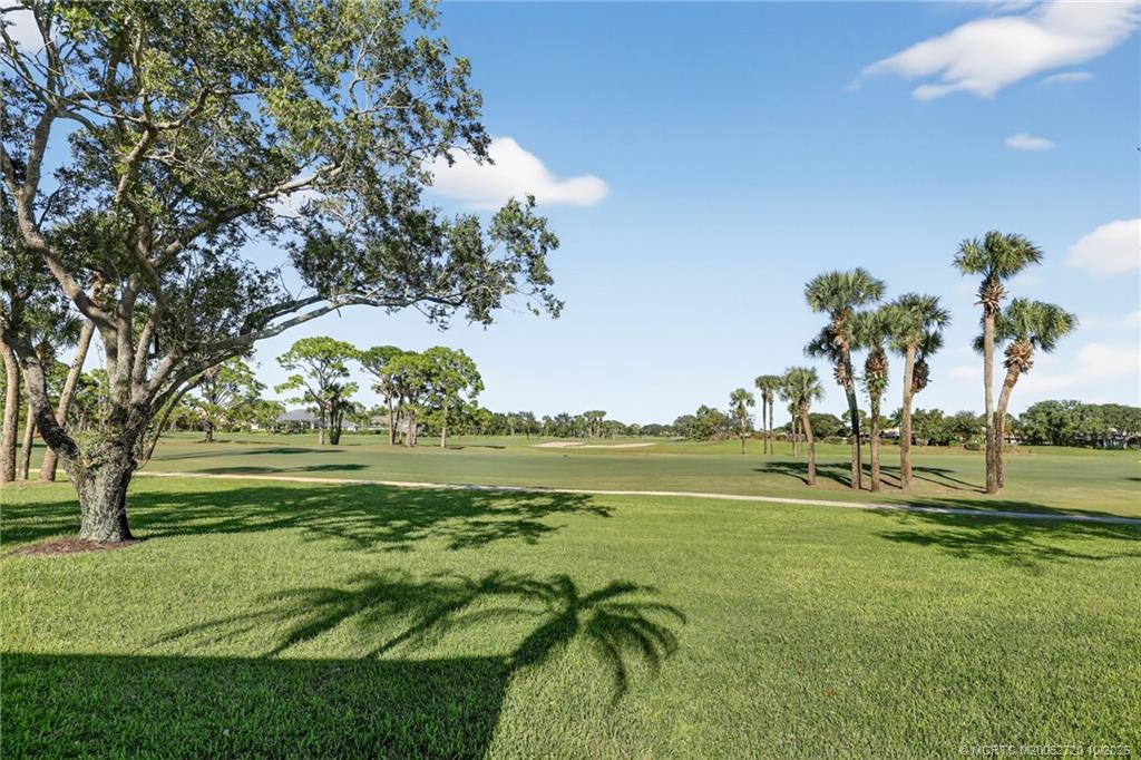6957 Southeast Pacific Drive Stuart, FL 34997 - Photo 41 of 71 a view of swimming pool with a garden and trees