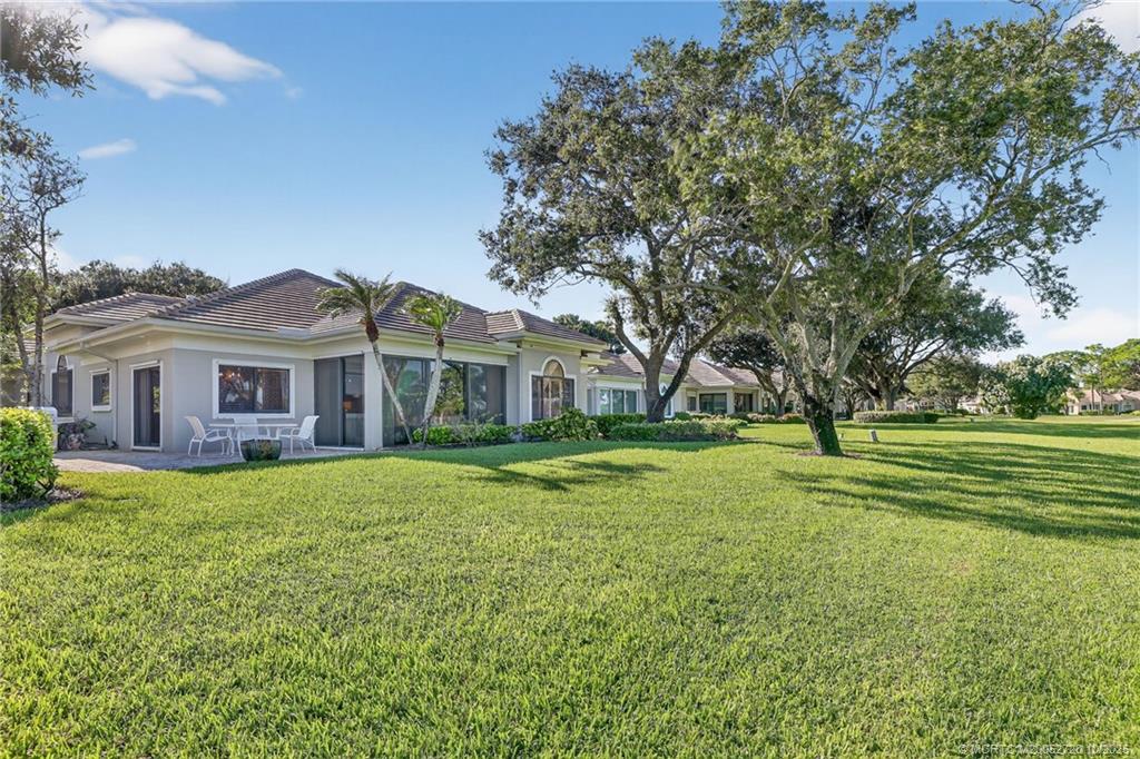 6957 Southeast Pacific Drive Stuart, FL 34997 - Photo 42 of 71 a front view of a house with a yard
