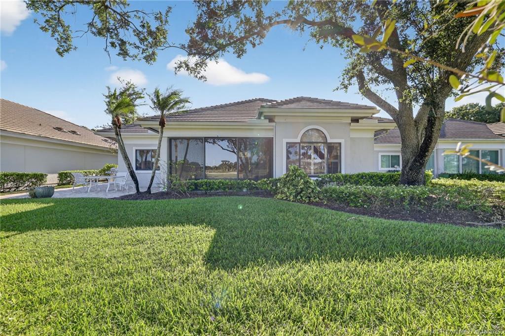 6957 Southeast Pacific Drive Stuart, FL 34997 - Photo 43 of 71 a front view of a house with a garden and plants