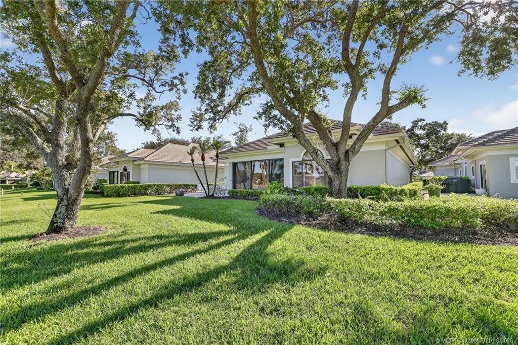 6957 Southeast Pacific Drive Stuart, FL 34997 - Photo 44 of 71 a front view of a house with yard and green space