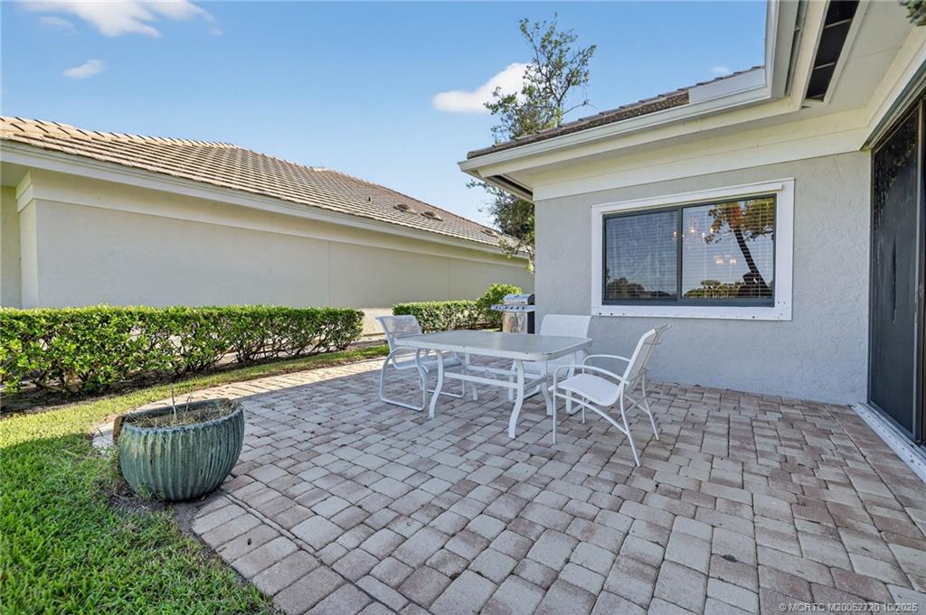 6957 Southeast Pacific Drive Stuart, FL 34997 - Photo 45 of 71 a view of a patio with table and chairs and potted plants