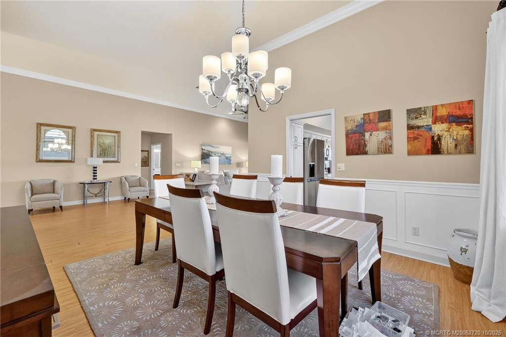 6957 Southeast Pacific Drive Stuart, FL 34997 - Photo 8 of 71 a view of a dining room with furniture and chandelier