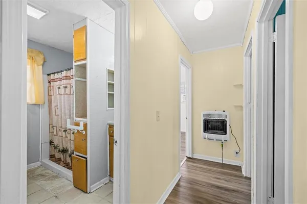 a view of a hallway with wooden floor and a rooms
