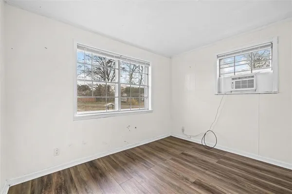 a view of a room with wooden floor and windows