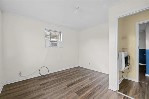 a room with a wooden floor and a window