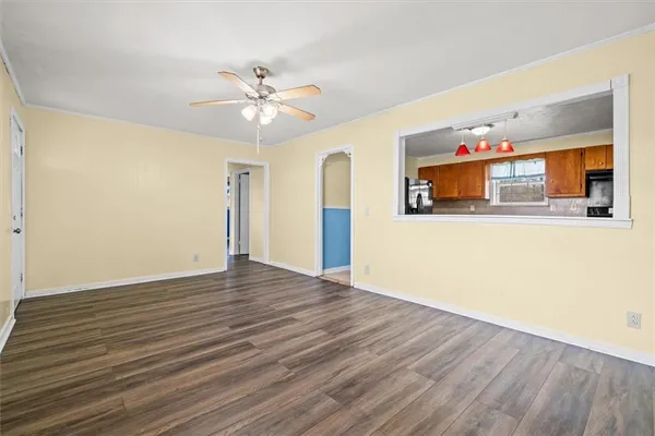 a view of a room with wooden floor and ceiling fan