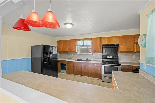 a kitchen with stainless steel appliances granite countertop a stove refrigerator and microwave