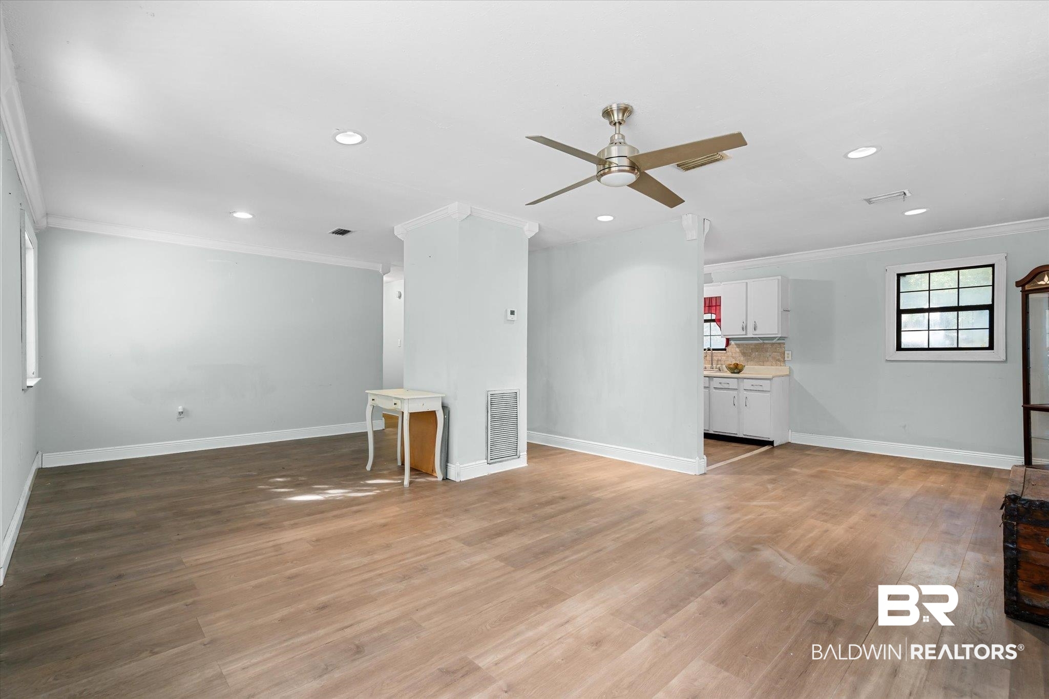 6233 Ponder Road Fairhope, AL 36532 - Photo 5 of 20 Unfurnished living room with crown molding, light hardwood / wood-style flooring, and ceiling fan