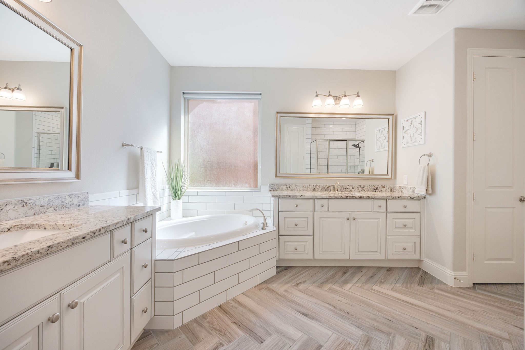 13103 Six Rivers Drive Humble, TX 77346 - Photo 13 of 44 The en-suite bath features dual sinks, granite counters, a soaking tub, and a walk-in shower complemented by statement mirrors, and stunning herringbone tile detail.