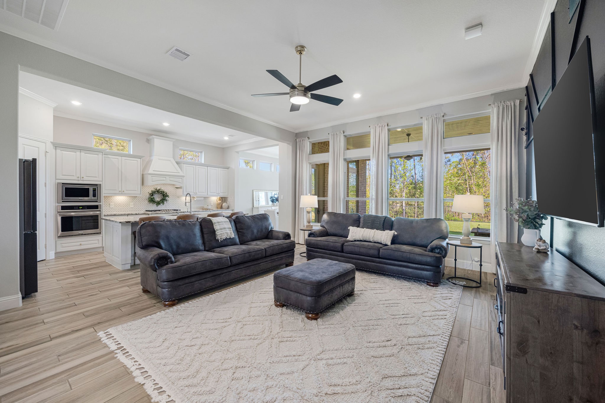 13103 Six Rivers Drive Humble, TX 77346 - Photo 3 of 44 Open-concept living designed for effortless entertaining, lined with windows that fill the space with natural light and frame a peaceful wooded backyard view.