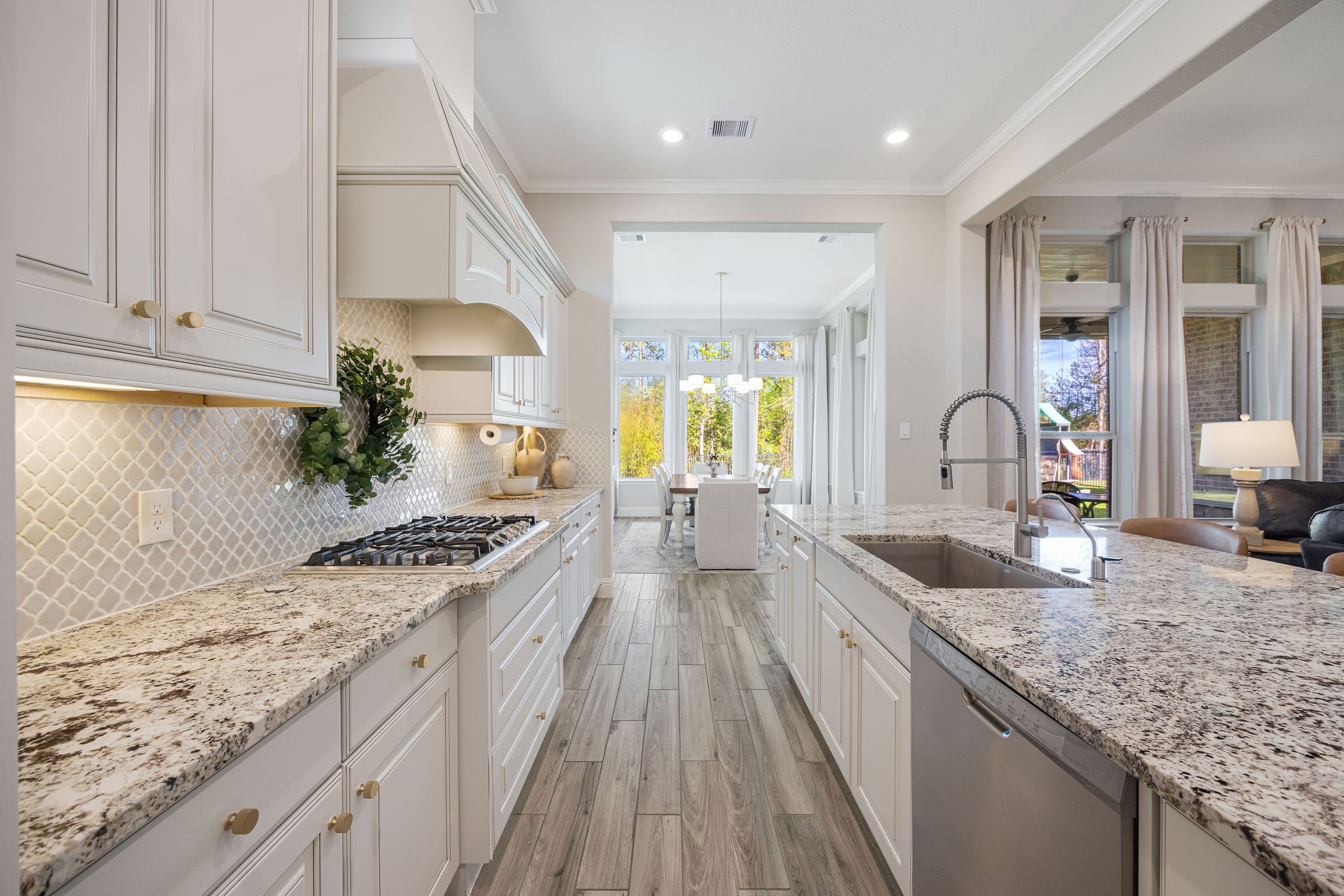 13103 Six Rivers Drive Humble, TX 77346 - Photo 6 of 44 A thoughtfully designed gourmet kitchen with no detail overlooked, featuring granite countertops, a tile backsplash, and custom French country cabinetry.
