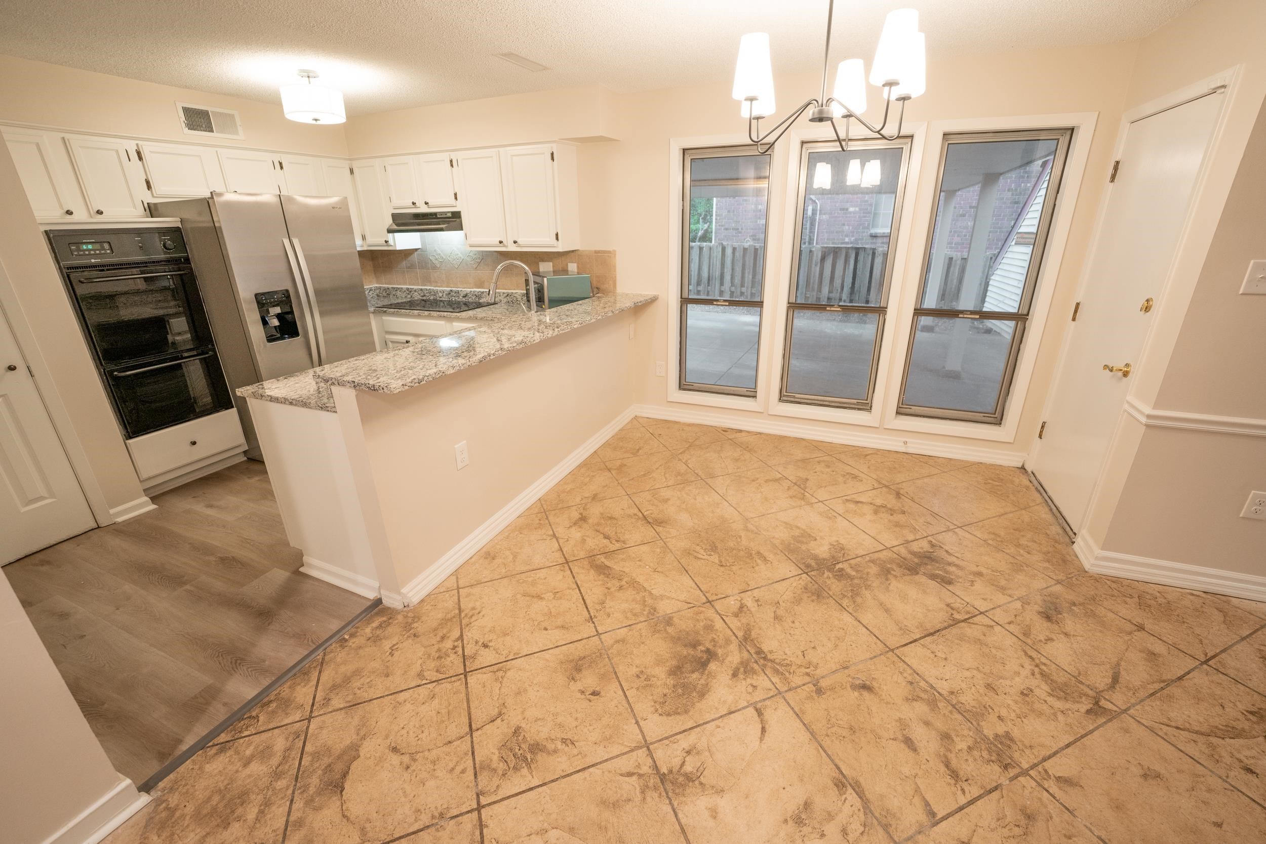 3054 Altruria Road Bartlett, TN 38134 - Photo 4 of 22 a view of a kitchen with stainless steel appliances wooden floor and a refrigerator