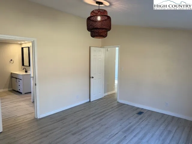a room with wooden floor and chandelier