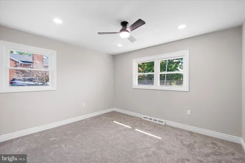an empty room with a window and a ceiling fan