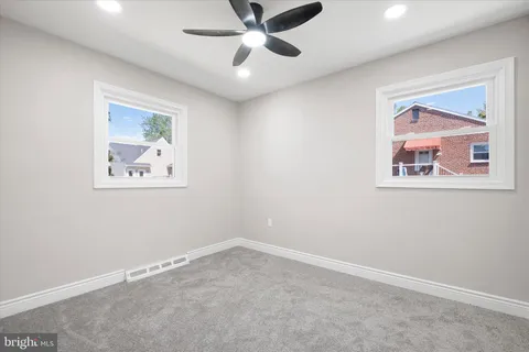 an empty room with fan and windows