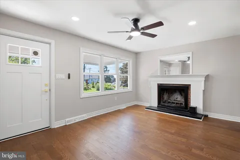 a view of an empty room with window and fire place