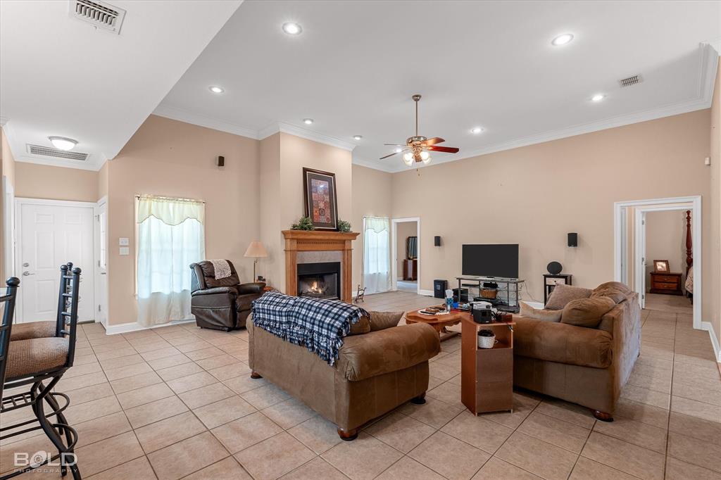 129 Wax Wing Drive Stonewall, LA 71078 - Photo 15 of 40 a living room with furniture a fireplace and a flat screen tv
