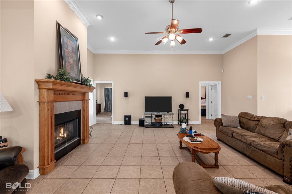 129 Wax Wing Drive Stonewall, LA 71078 - Photo 21 of 40 a living room with furniture a fireplace and a flat screen tv