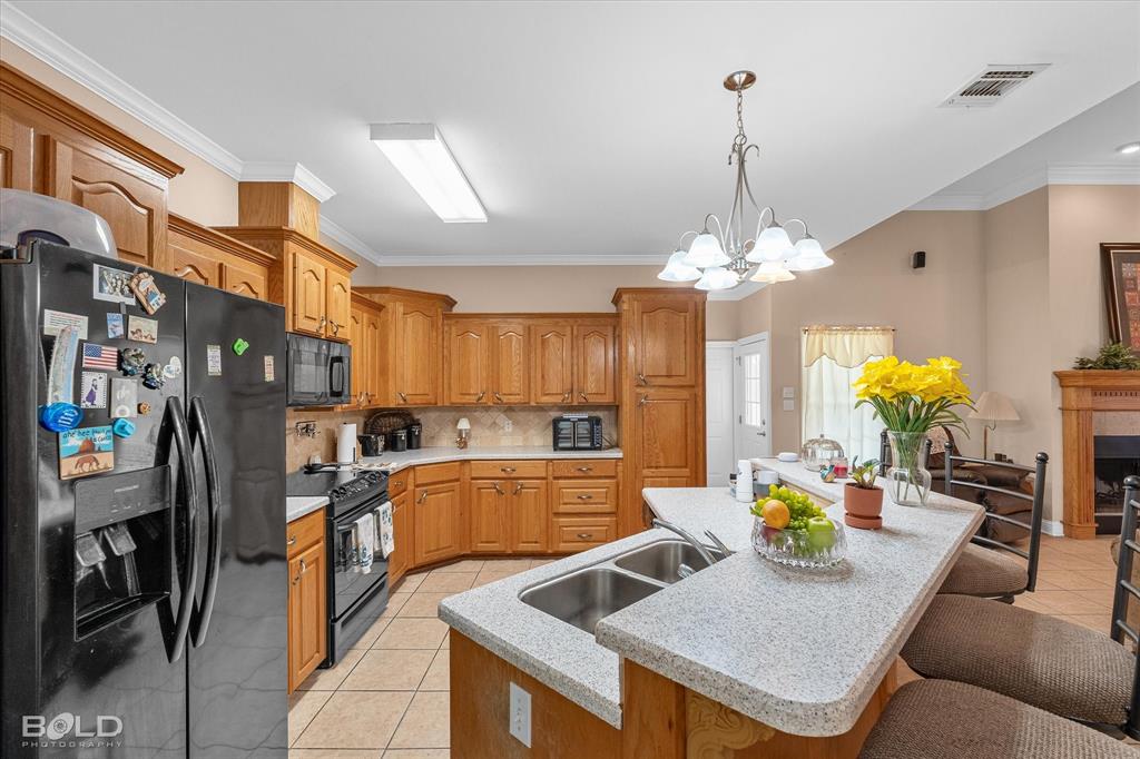 129 Wax Wing Drive Stonewall, LA 71078 - Photo 23 of 40 a kitchen with stainless steel appliances granite countertop a sink dishwasher a dining table and chairs with wooden floor