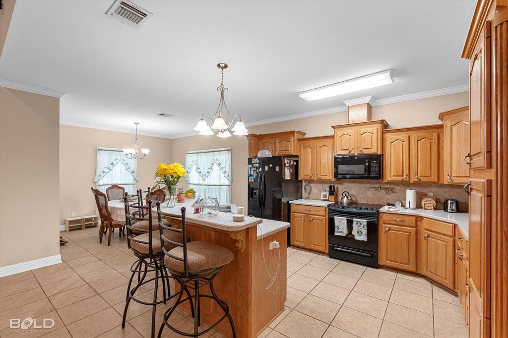 129 Wax Wing Drive Stonewall, LA 71078 - Photo 25 of 40 a open kitchen with stainless steel appliances kitchen island granite countertop a sink and cabinets