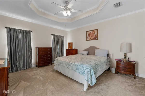 a spacious bedroom with a bed and a chandelier