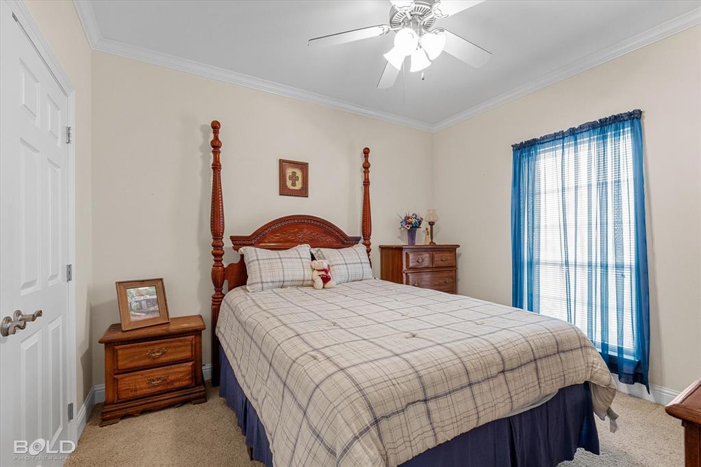 129 Wax Wing Drive Stonewall, LA 71078 - Photo 34 of 40 a bedroom with a bed and a chandelier