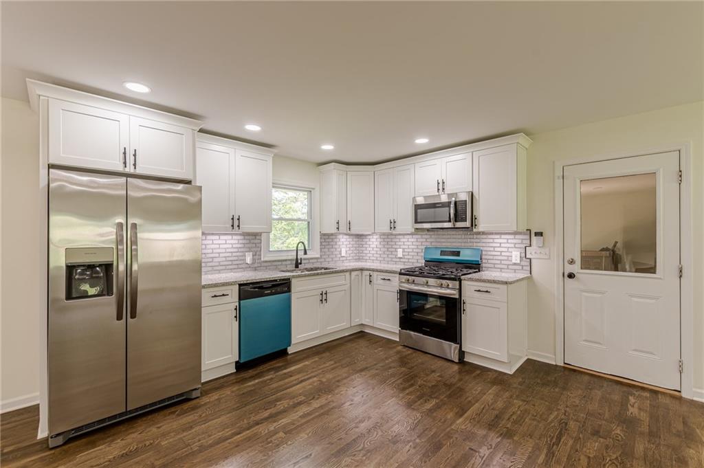 3275 Clifton Church Road Southeast Atlanta, GA 30316 - Photo 16 of 59 a kitchen with stainless steel appliances granite countertop a refrigerator and a stove top oven