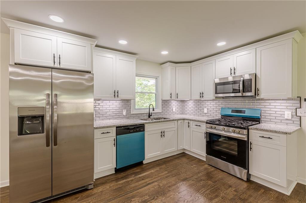 3275 Clifton Church Road Southeast Atlanta, GA 30316 - Photo 17 of 59 a kitchen with stainless steel appliances granite countertop a refrigerator a stove a sink and a microwave