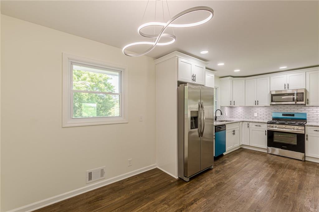 3275 Clifton Church Road Southeast Atlanta, GA 30316 - Photo 20 of 59 a kitchen with a refrigerator cabinets and wooden floor