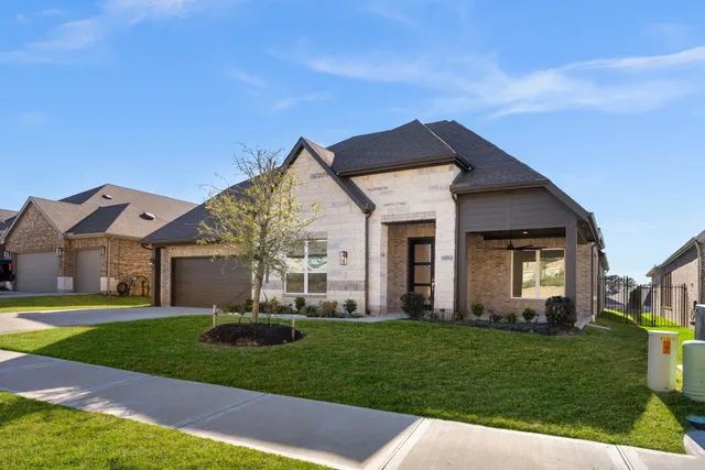a front view of a house with a yard and trees