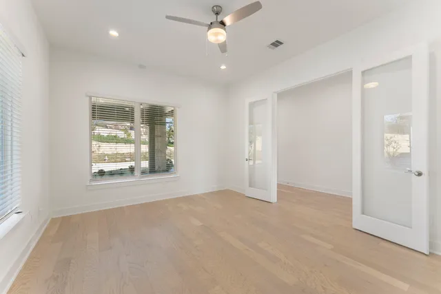an empty room with fan and windows