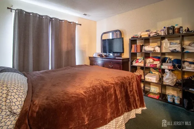 a spacious bedroom with a bed and a television