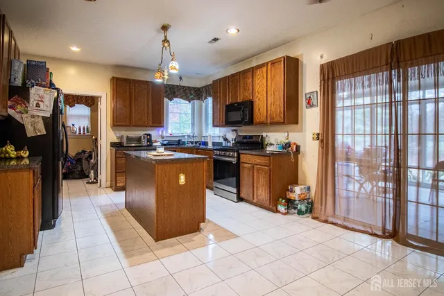 a kitchen with stainless steel appliances granite countertop a stove top oven a sink a counter top space and cabinets