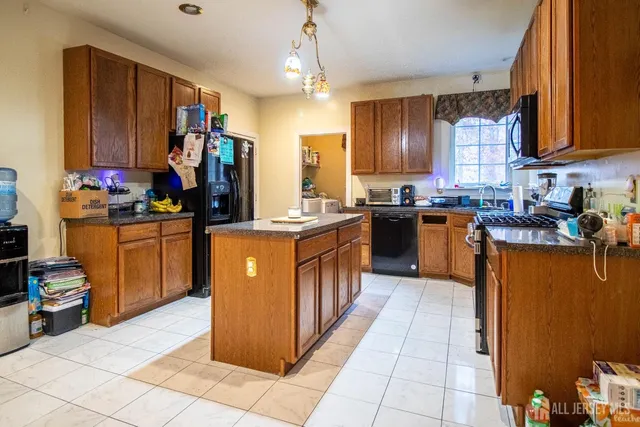 a kitchen with stainless steel appliances granite countertop a stove a sink dishwasher and a refrigerator