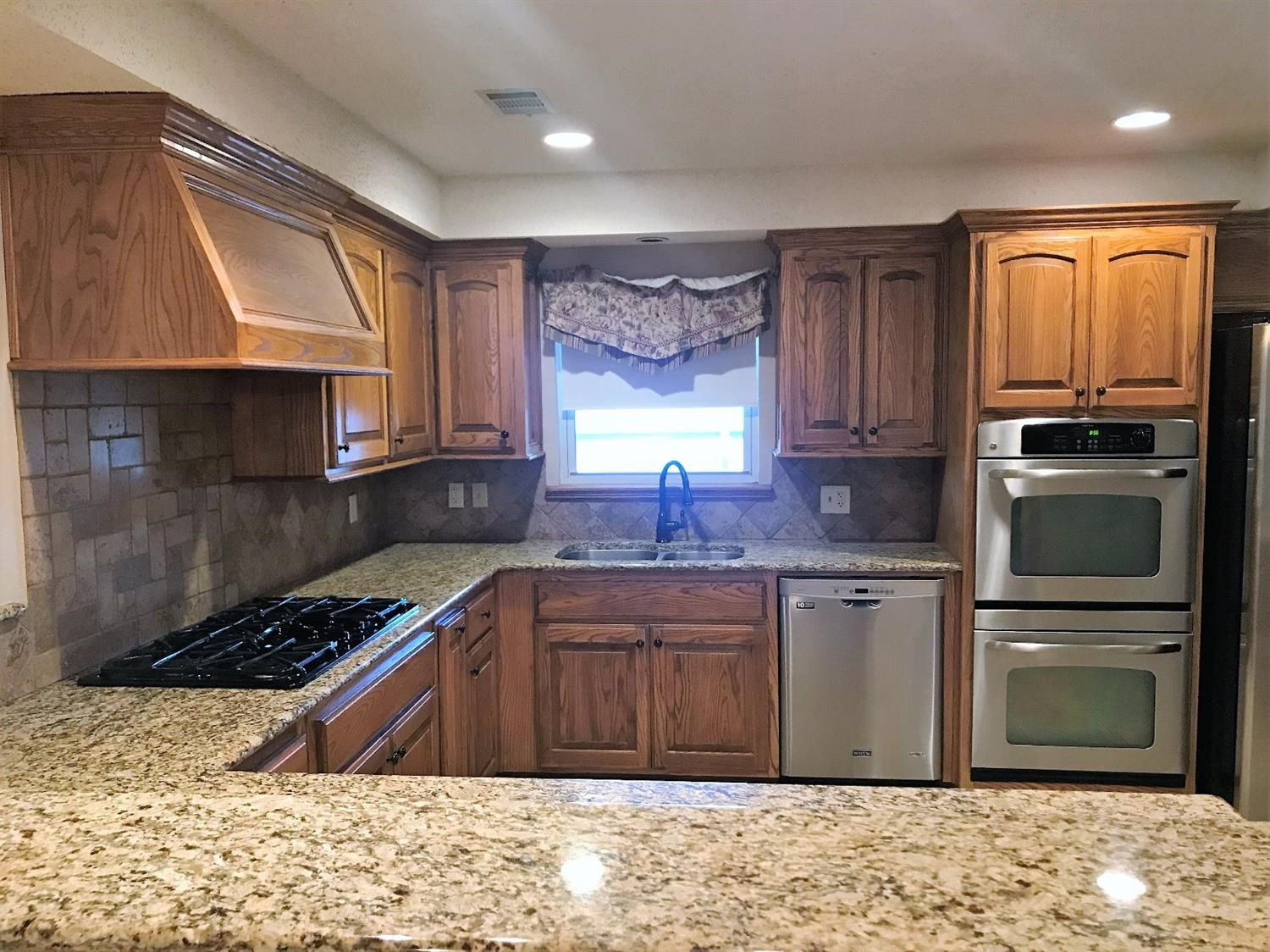 305 Ranch Street Ropesville, TX 79358 - Photo 3 of 10 a kitchen with stainless steel appliances granite countertop a stove a sink and a microwave
