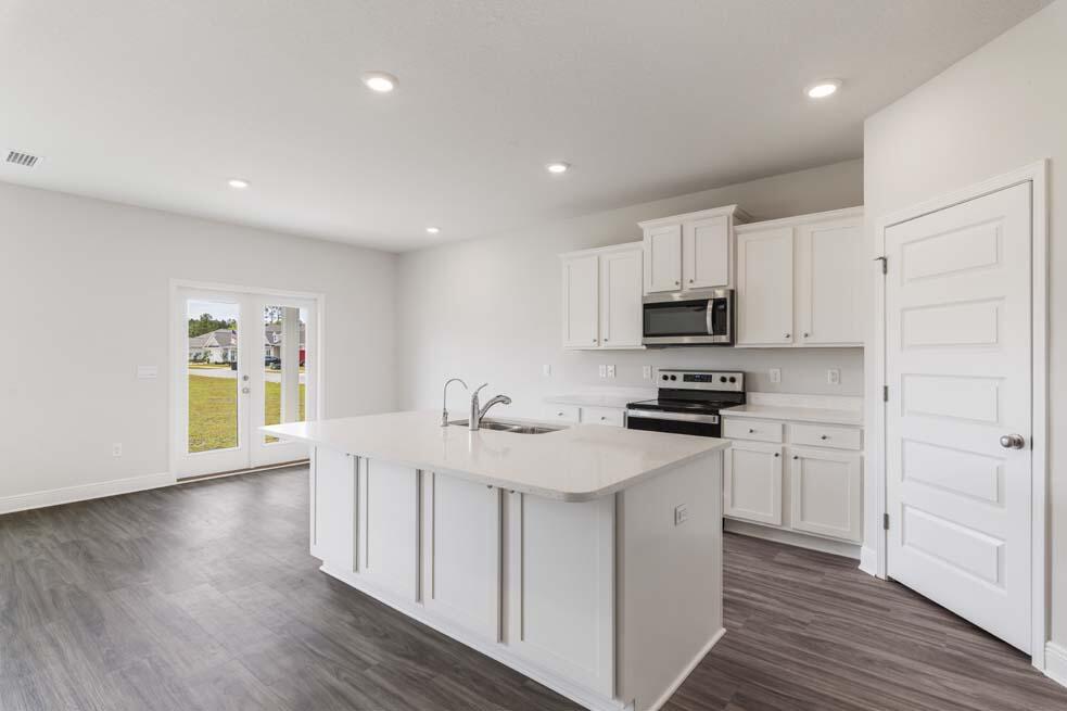 44 Oak Trees Lane West Freeport, FL 32439 - Photo 9 of 23 a kitchen with white cabinets stainless steel appliances and wooden floor