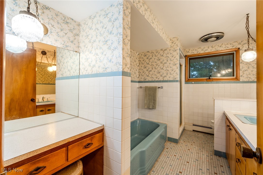 1950 Rush Road Wickliffe, OH 44092 - Photo 22 of 50 Bathroom featuring vanity, light tile patterned flooring, wallpapered walls, a garden tub, and tile walls