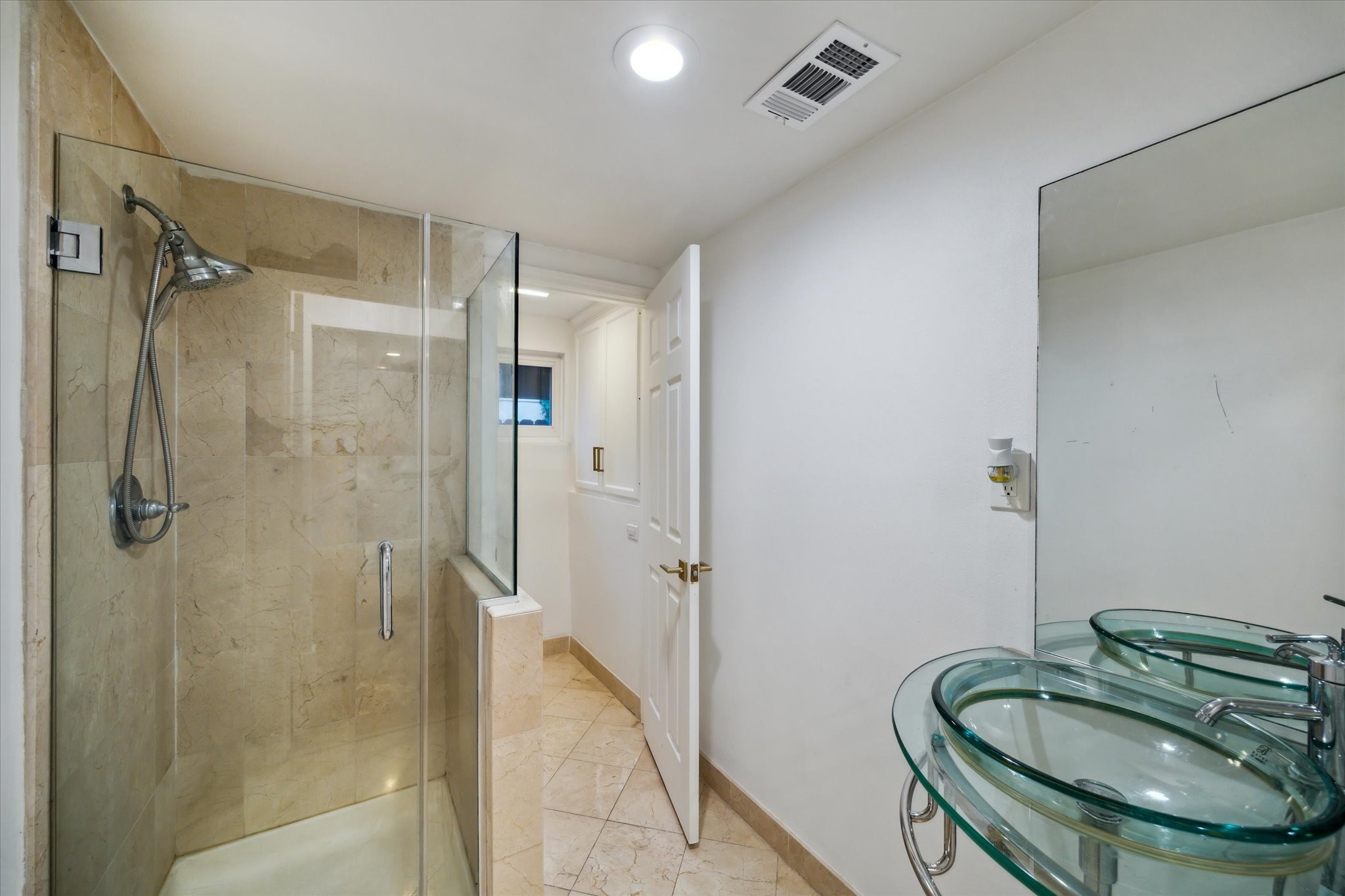 6321 Deerwood Road Houston, TX 77057 - Photo 29 of 34 Additional full bathroom with glass-enclosed tiled shower and contemporary glass vessel sink.